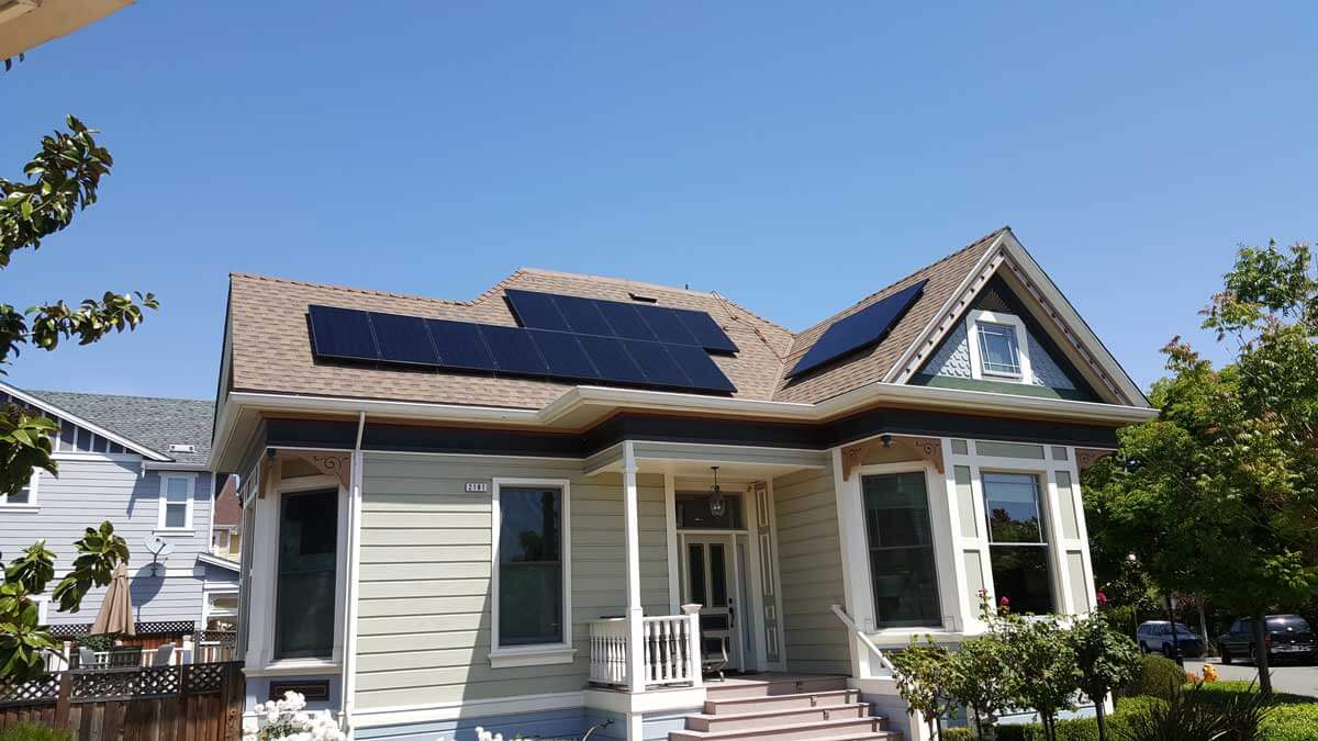 Small Victorian house with solar panels on different parts of sloped roof
